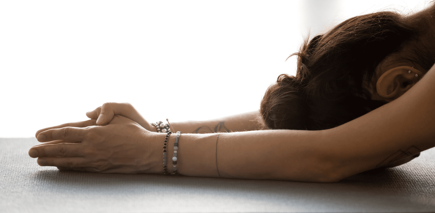 woman in childs pose on a yoga mat